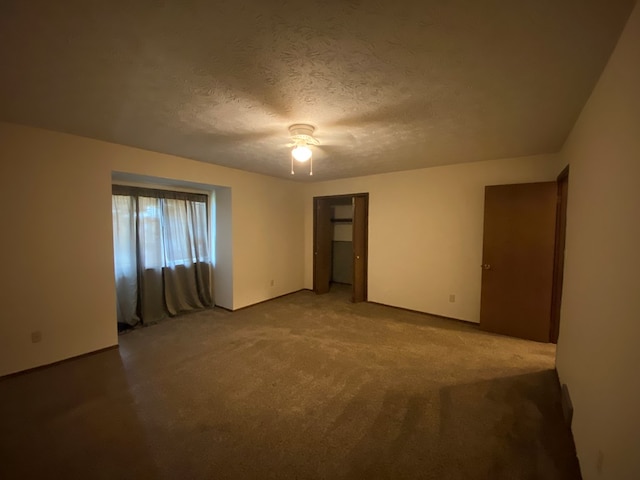 carpeted spare room featuring a textured ceiling