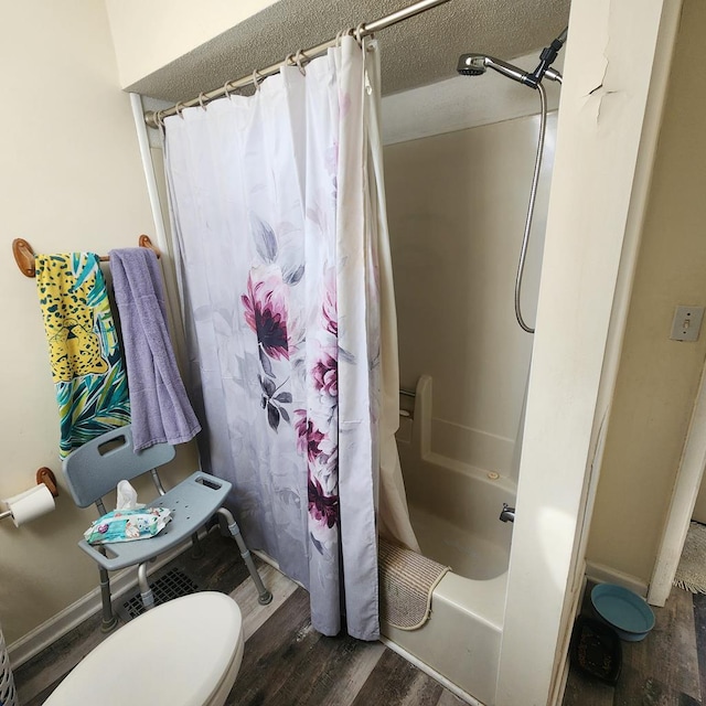 full bathroom featuring toilet, a textured ceiling, shower / bath combo with shower curtain, and wood finished floors