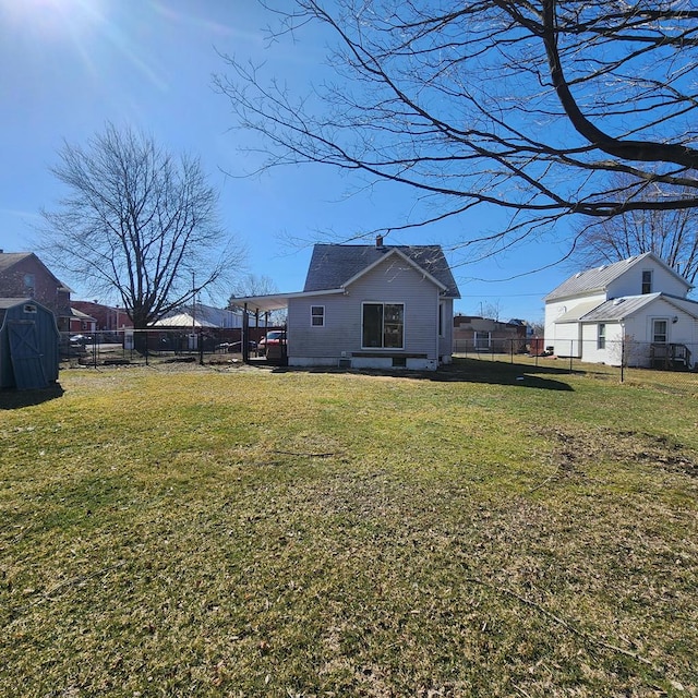 rear view of house featuring a yard and a fenced backyard