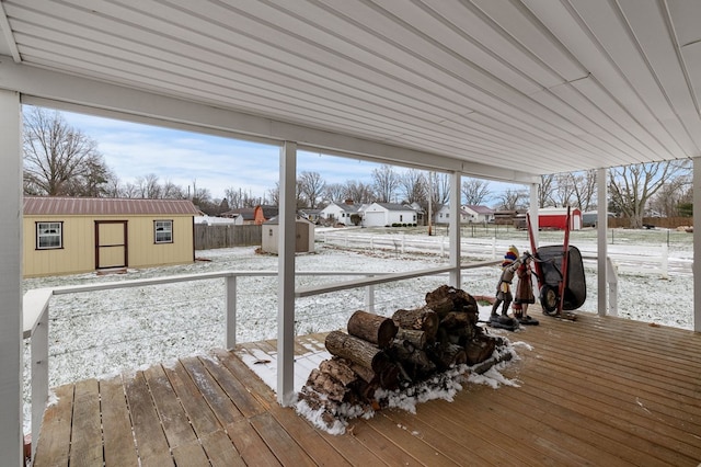 snow covered deck featuring a shed