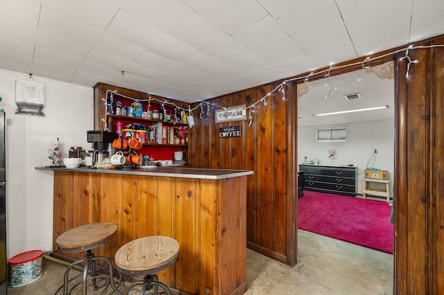 bar with wooden walls and light colored carpet