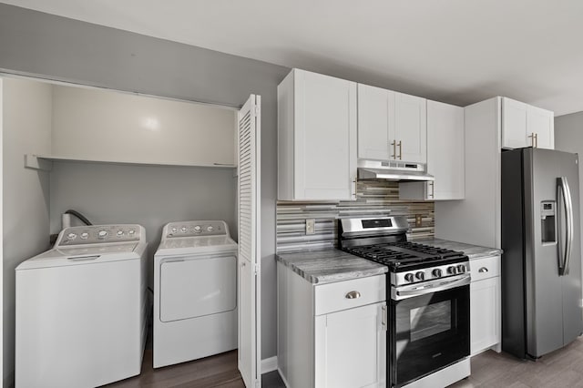 kitchen featuring backsplash, under cabinet range hood, appliances with stainless steel finishes, white cabinets, and independent washer and dryer