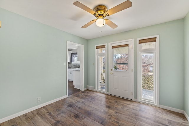 entryway featuring dark wood-style floors, a ceiling fan, and baseboards