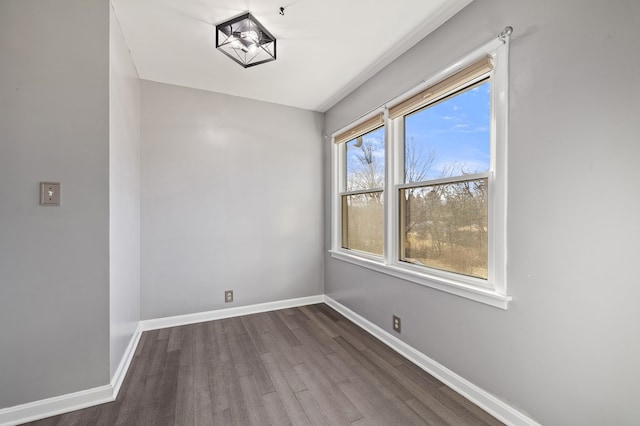 spare room with dark wood finished floors and baseboards