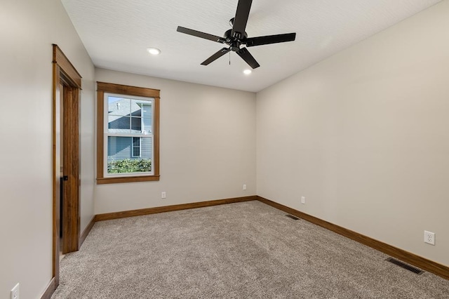 carpeted spare room with ceiling fan