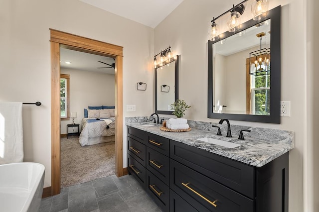 bathroom featuring a washtub, vanity, a wealth of natural light, and ceiling fan