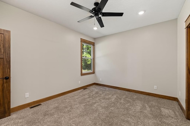 carpeted spare room with ceiling fan