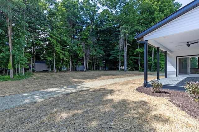 view of yard featuring ceiling fan and a wooden deck