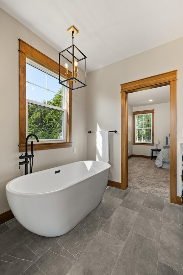 bathroom featuring a bathing tub and a notable chandelier