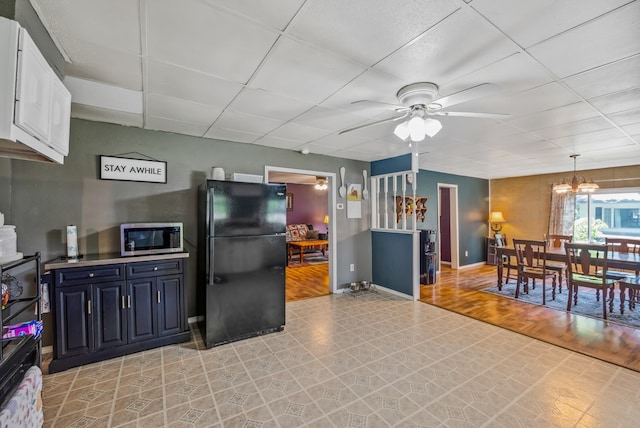 247 3rd St, Larue, OH 43332 - kitchen with freestanding refrigerator, stainless steel microwave, ceiling fan, a paneled ceiling, and a chandelier