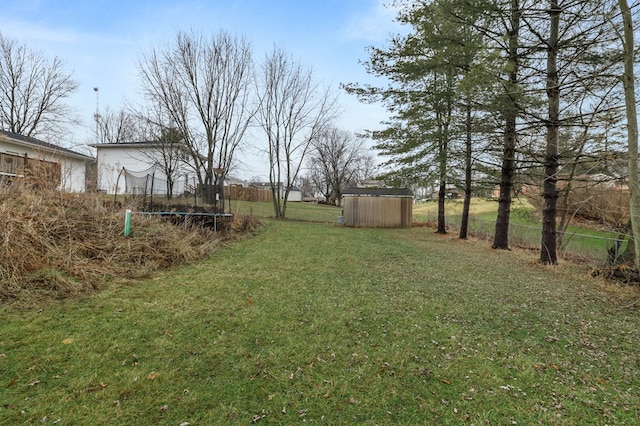 view of yard with a trampoline and a shed