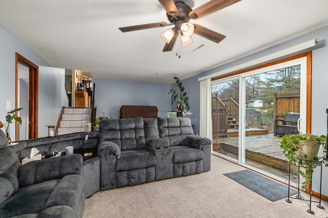 carpeted living room with ceiling fan and a textured ceiling