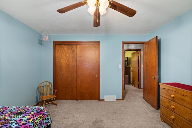 bedroom featuring ceiling fan, light colored carpet, and a closet