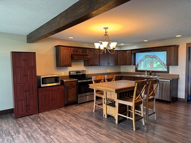 227 S Jefferson St, Loudonville, OH 44842 - kitchen featuring appliances with stainless steel finishes, dark wood finished floors, a textured ceiling, under cabinet range hood, and recessed lighting