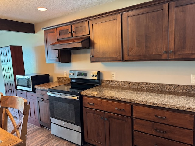 227 S Jefferson St, Loudonville, OH 44842 - kitchen with stainless steel appliances, premium range hood, dark wood-style floors, a textured ceiling, and dark countertops