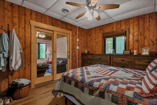 58 Edgewood Dr, Perrysville, OH 44864 - bedroom featuring wood walls, multiple windows, access to outside, a paneled ceiling, and light wood-style floors