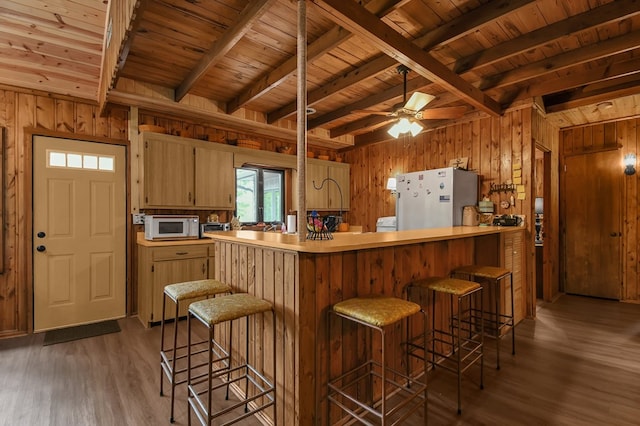 58 Edgewood Dr, Perrysville, OH 44864 - kitchen with freestanding refrigerator, white microwave, wood walls, wood finished floors, and wooden ceiling with exposed beams
