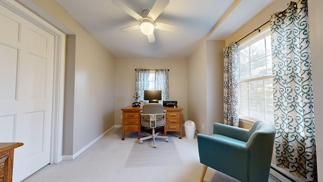 home office with a baseboard heating unit, light carpet, ceiling fan, and baseboards