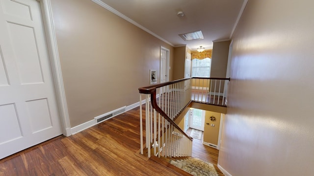 stairs featuring visible vents, wood finished floors, baseboards, and ornamental molding