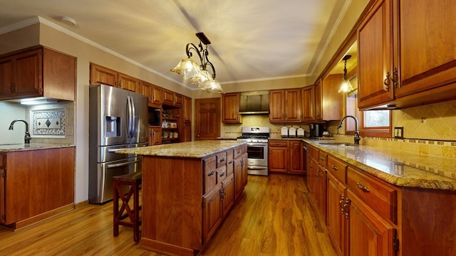 kitchen with stainless steel appliances, wood finished floors, light stone countertops, and a sink