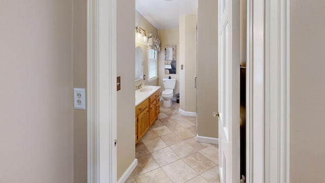 bathroom featuring toilet, baseboards, tile patterned floors, and vanity
