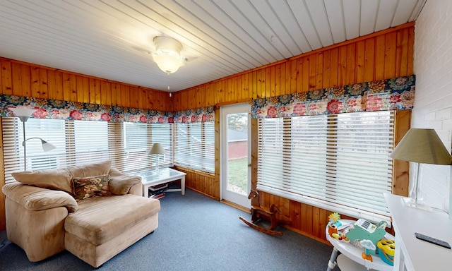 sunroom with carpet flooring and wood walls