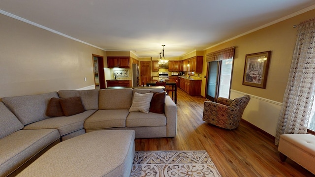living room with baseboards, ornamental molding, and wood finished floors