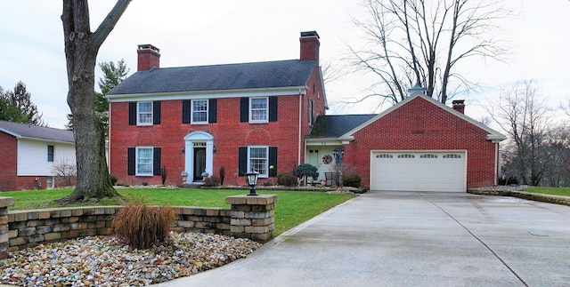 colonial inspired home with concrete driveway, brick siding, a chimney, and a garage