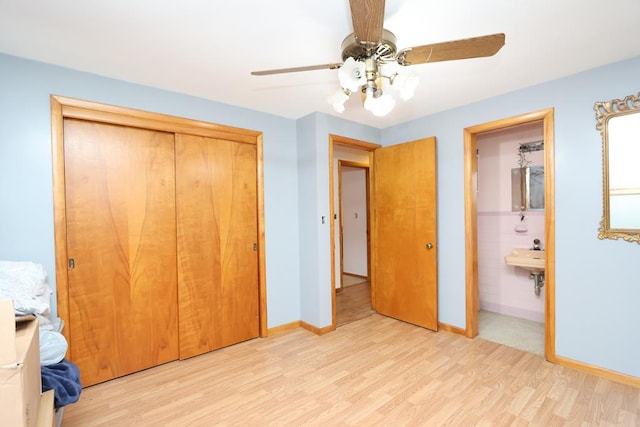 unfurnished bedroom featuring a closet, light wood-style flooring, baseboards, connected bathroom, and a ceiling fan