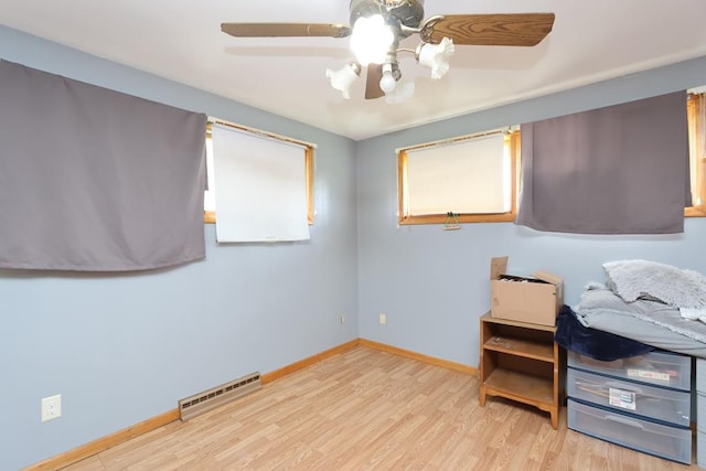 bedroom featuring wood finished floors, baseboards, ceiling fan, and visible vents