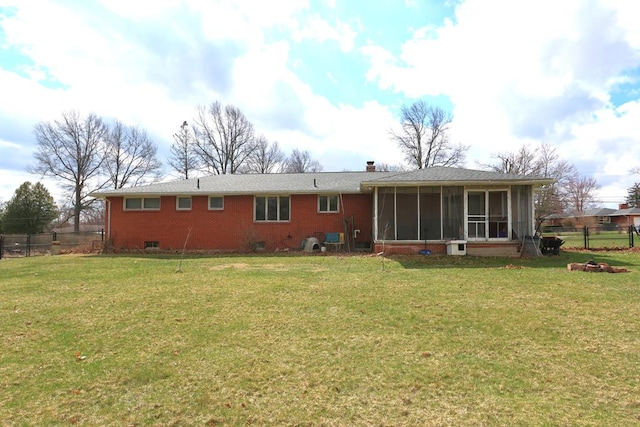 back of house with a chimney, a sunroom, and a yard