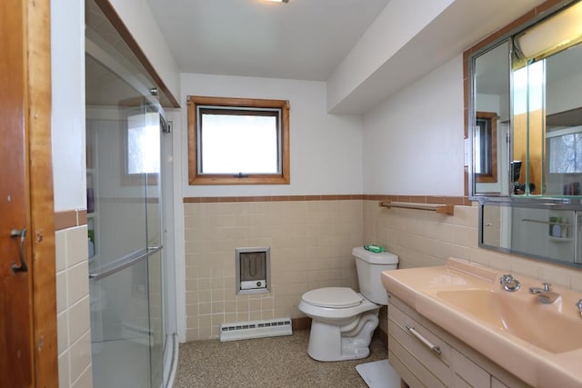 full bath with a stall shower, a wainscoted wall, vanity, baseboard heating, and tile walls