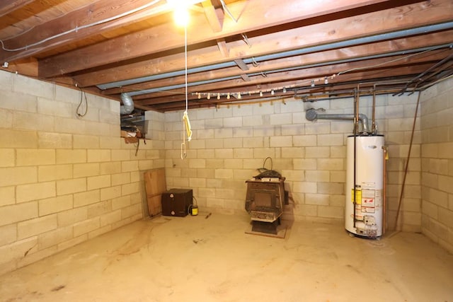 unfinished basement with water heater and a wood stove