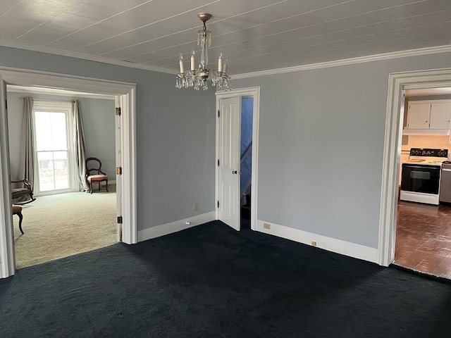 spare room featuring dark carpet, ornamental molding, and a chandelier