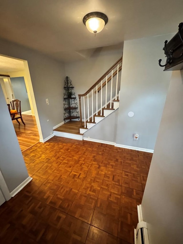 foyer entrance featuring stairway and baseboards