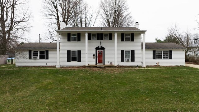 view of front facade with a chimney and a front lawn