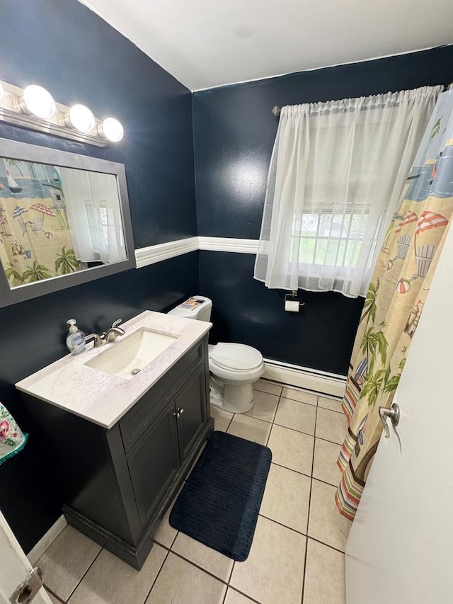 bathroom with tile patterned floors, baseboard heating, toilet, vanity, and baseboards