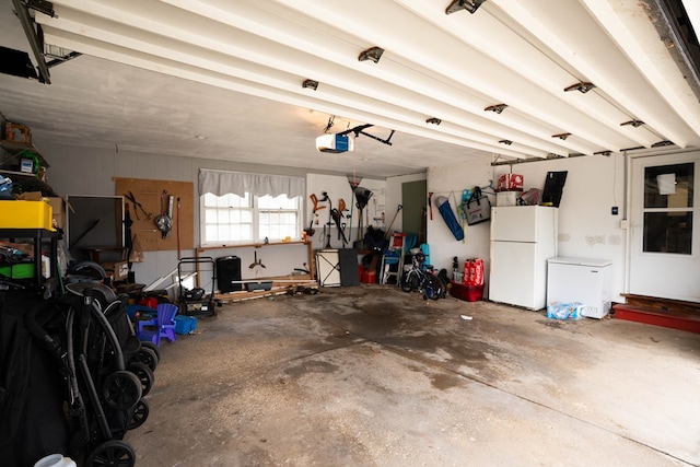 garage with freestanding refrigerator and a garage door opener