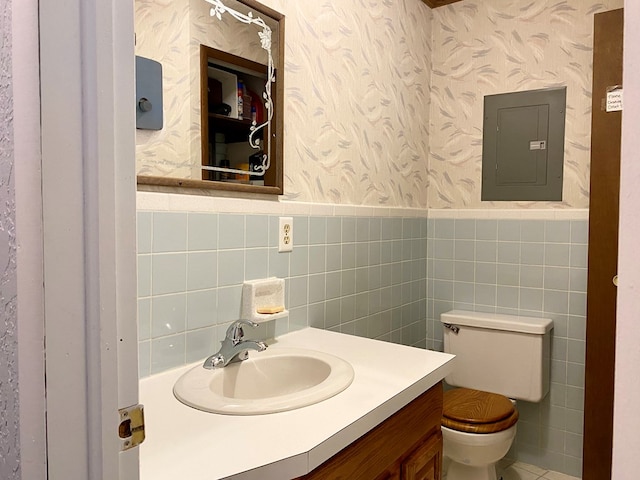 bathroom with vanity, toilet, tile walls, and electric panel