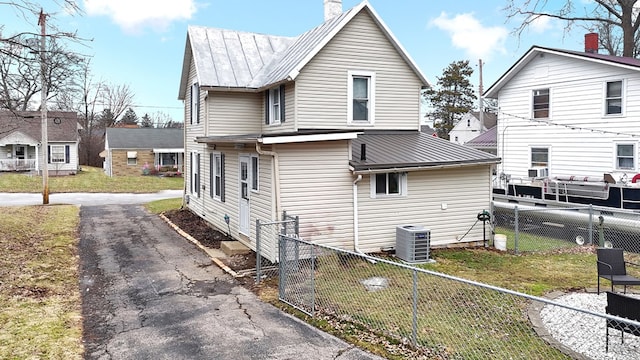 exterior space with cooling unit and a lawn