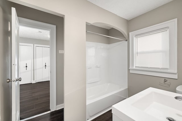 459 Glessner Ave, Mansfield, OH 44903 - bathroom featuring a textured ceiling, wood finished floors, tub / shower combination, a sink, and baseboards