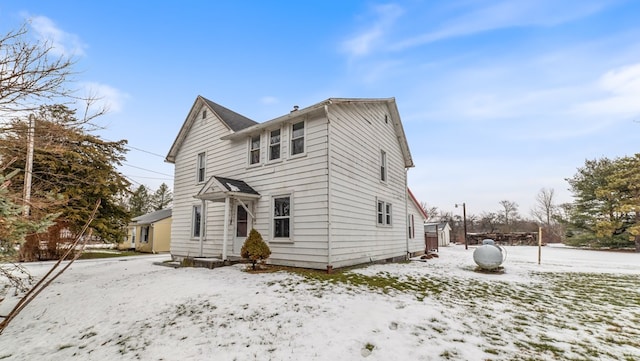 view of snow covered back of property