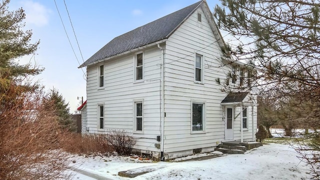 view of snow covered rear of property