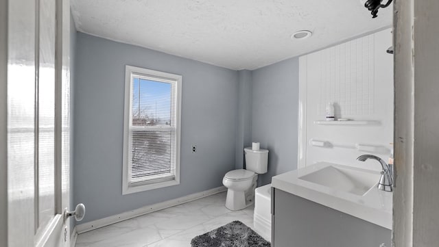 bathroom with vanity, toilet, and a textured ceiling