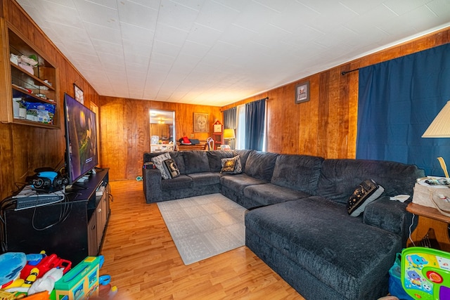 living room with wooden walls and light hardwood / wood-style flooring