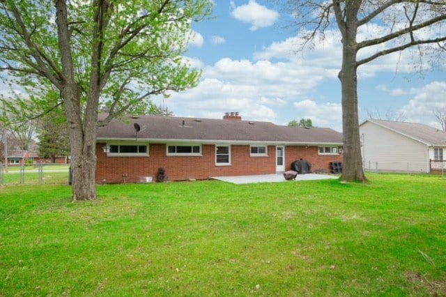 back of property featuring a yard and a patio