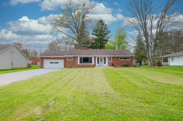 ranch-style home with a front yard and a garage