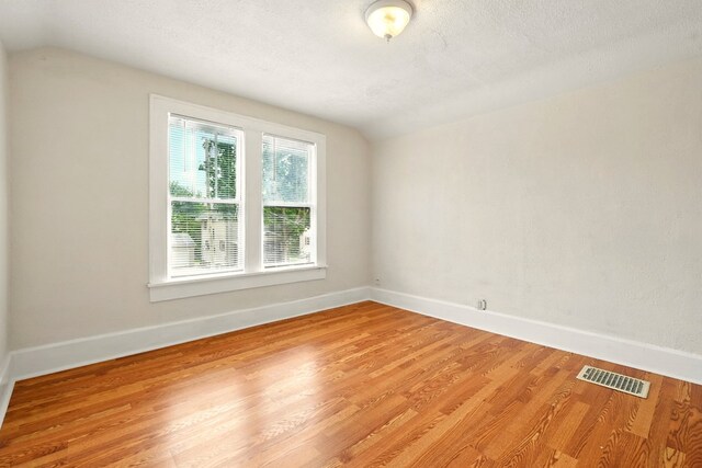 411 Grace St, Mansfield, OH 44902 - spare room with lofted ceiling, light wood-style floors, baseboards, and a textured ceiling