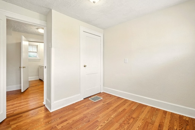 411 Grace St, Mansfield, OH 44902 - unfurnished bedroom with light wood-style flooring, baseboards, a textured ceiling, and a closet
