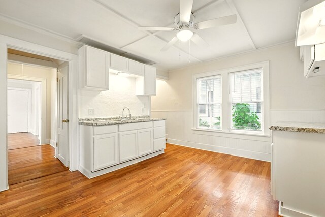 411 Grace St, Mansfield, OH 44902 - kitchen featuring light wood-style flooring, a ceiling fan, white cabinetry, light stone counters, and wainscoting
